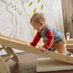Un jeune enfant aime grimper sur une échelle en bois à l’intérieur, favorisant ainsi le jeu et l’activité.